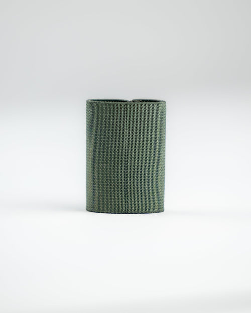 A dark green SLIM carry standing upright on a clean white studio background.