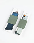 Two olive green elastic gun belt wraps holding magazines on white display cards, photographed on a clean white background.