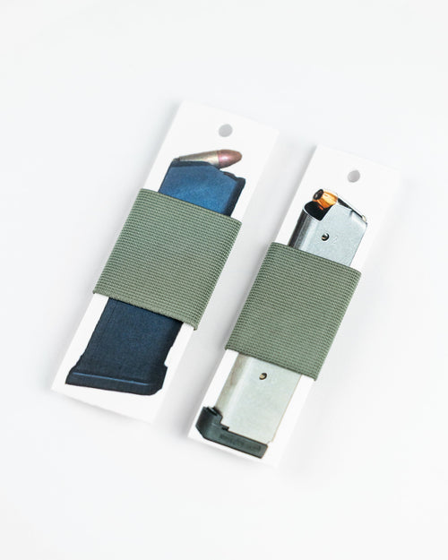 Two olive green elastic gun belt wraps holding magazines on white display cards, photographed on a clean white background.